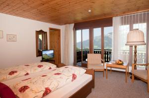 1 Schlafzimmer mit 2 Betten und einem großen Fenster in der Unterkunft Hotel Arvenbüel in Amden