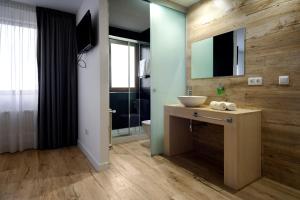 a bathroom with a sink and a toilet and a mirror at Hotel Montañés in Suances +40 photos