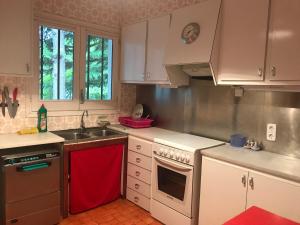 una cocina con armarios blancos y una toalla roja en CASA RURAL " REFUGI TACITA-CAPDELLA ", en Capdella