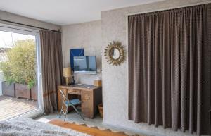 a bedroom with a desk with a television and a window at Kook Hotel Tarifa in Tarifa
