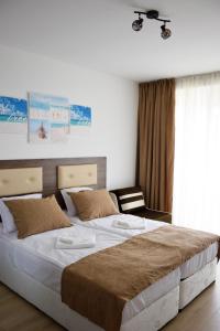 a bedroom with a large bed and a chair at studio ASI in Obzor