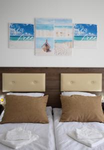 a bedroom with two beds and pictures on the wall at studio ASI in Obzor