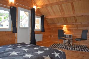 een slaapkamer met een bed en 2 stoelen in een kamer bij Chalet Les Prés in Neubois