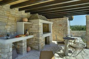a patio with an outdoor kitchen with a stone wall at Villa Paradiso in Rovinj