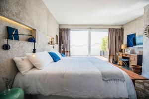 a bedroom with a large bed and a large window at Kook Hotel Tarifa in Tarifa