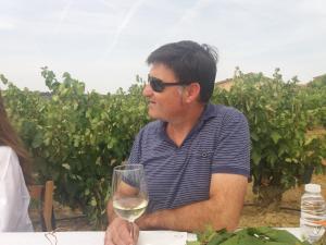a man sitting at a table with a glass of wine at Carpe Diem in Navaridas