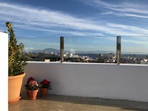 a balcony with potted plants and a view of a city at Kook Hotel Tarifa in Tarifa