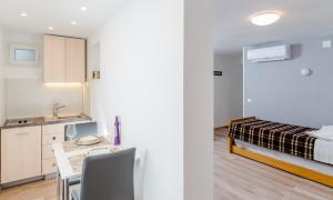 a kitchen and a bedroom with a bed and a table at 2 Apartmans "Metro" and "Gum" in Split