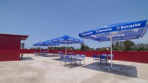 a group of blue tables and chairs under umbrellas at Hotel Chakvi in Chakvi