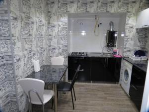 a kitchen with a table and chairs and a sink at Apartment Tamara On Khandzteli Street in Tbilisi City