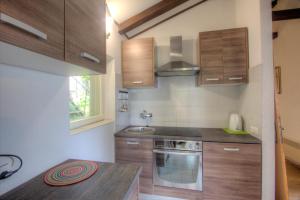 a kitchen with wooden cabinets and a stove top oven at Premium Apartments Punta Kolova in Opatija