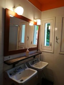 a bathroom with two sinks and a mirror at CASA RURAL " REFUGI TACITA-CAPDELLA " in Capdella