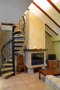 a living room with a fireplace and a spiral staircase at La Azacaya in Baeza