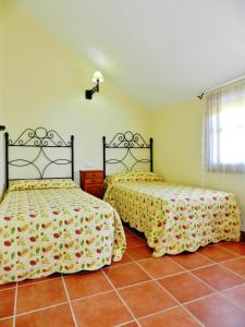 a bedroom with two beds and a tile floor at La Quinta de María Luisa in Zahora