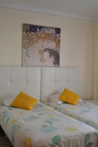 トレモリノスにあるHof van Holland Carihuelaのベッドルーム1室(ベッド2台付)が備わります。壁には絵画が飾られています。