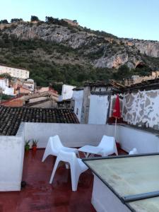 einen Balkon mit zwei weißen Stühlen und einem Tisch in der Unterkunft Casa Rural Xàtiva in Xàtiva