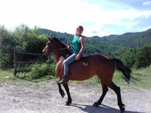 Una donna che cavalca un cavallo su una strada sterrata di Le Chianine dei Tognoli a Gragnola