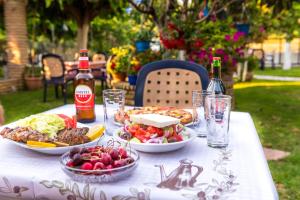 una mesa con platos de comida y botellas de cerveza en Elena Apartments, en Kanali