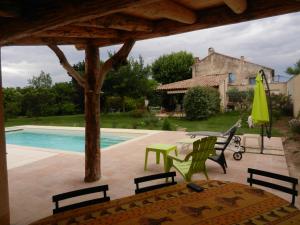 a patio with a table and chairs and a pool at La Fenière aux Hirondelles in Orange