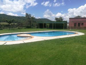 a swimming pool in a grassy yard with a building at Camping La Ribera Salada in Ogern