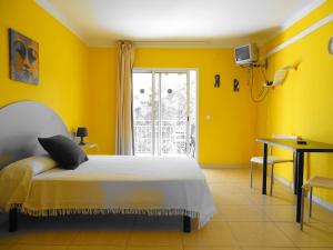 Dormitorio amarillo con cama y ventana en Rex Apartment, en Salou