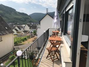 a balcony with two tables and an umbrella at Beim Winzer in Zell an der Mosel