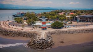 a lighthouse on the beach with a boat in the water at Hotel Sol Puntarenas in Puntarenas