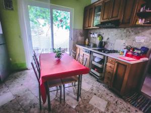 ドゥブロヴニクにあるアンチ ゲストハウスの赤いテーブル、赤いテーブルと椅子付きのキッチン
