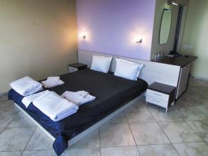 ein Schlafzimmer mit einem Bett mit zwei Kissen darauf in der Unterkunft Afrodita Hotel in Sinemorets