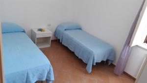 um pequeno quarto com duas camas e uma mesa em Casa vacanze Filomena em Marina di Camerota