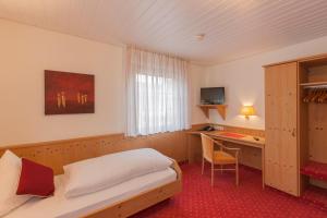 a hotel room with a bed and a desk at Löwen Hotel & Restaurant in Wendlingen am Neckar