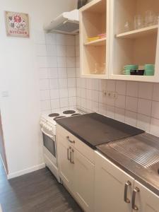 Una cocina con gabinetes blancos y una estufa. en La Laverie, en Saint-Jean-dʼAngély