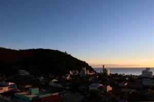 a view of a city with a hill in the background at Curta Praia do Quilombo - Lunata in Penha