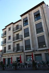 a building with chairs and umbrellas in front of it at Hostal Torres in San Leonardo de Yagüe