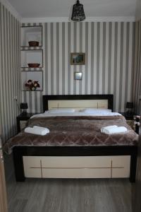 a bed in a bedroom with striped walls at Travel Inn House Mestia • მოგზაურის სახლი in Mestia