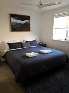a bedroom with a large bed with two towels on it at FortyOne - Oceanside Retreat Busselton in Busselton