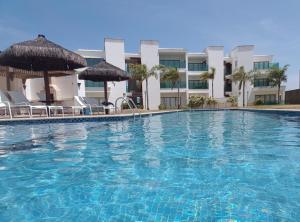 uma grande piscina com cadeiras e guarda-sóis em Condominio Mediterraneo - Iberostate na Praia do Forte