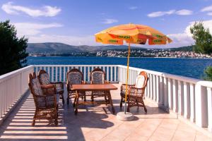 einen Tisch mit Stühlen und einem Sonnenschirm auf dem Balkon in der Unterkunft Ricci Apartment in Trogir