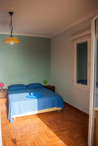 een slaapkamer met een blauw bed en een houten vloer bij Irimar retreat managed by Hilltop Residences in Mikra Mandinia