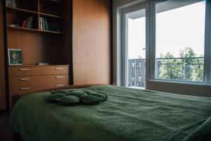 a bedroom with a green bed with two pillows on it at New apartament very close to the city centre in Vilnius