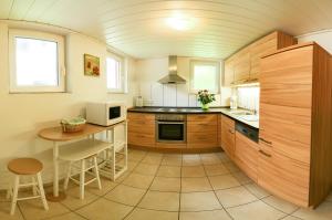 a kitchen with wooden cabinets and a table at Ferienwohnung am Schneeberg in Titisee-Neustadt