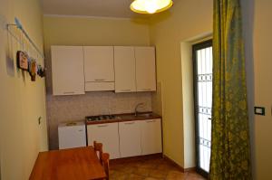 een keuken met witte kasten en een tafel en een raam bij Agriturismo Frangivento in Casa Giosafat