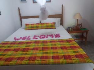 a bed with a sign that says we are coming at cocoa pod studio in Soufrière