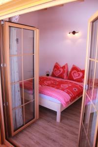 ブラームベルク・アム・ヴィルトコーゲルにあるMay-Hausの小さなベッドルーム(赤い枕のベッド付)
