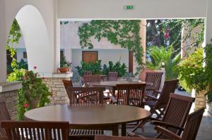 an outdoor patio with tables and chairs and plants at Ino Hotel & Suites in Samos