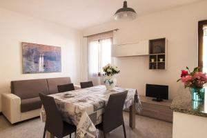 a dining room with a table and a couch at CASA VACANZA VALLEDORIA 2 in Valledoria