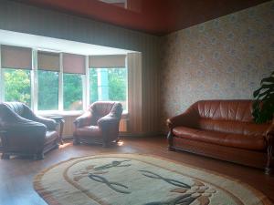 a living room with two chairs and a couch and a rug at Hotel Andreevsky in Vinnytsya