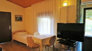 a small bedroom with a bed and a television at Apartments Rukavina in Umag