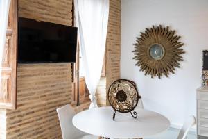 a dining room with a white table and a tv at My Loft 4 You Ruzafa Style III in Valencia