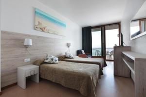 a hotel room with two beds and a balcony at Hotel Maria Teresa in Sant Antoni de Calonge